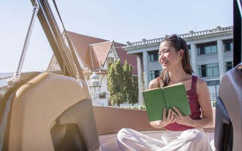 亚洲美丽的女人阅读书而旅行和坐着船与背景美丽的Lanscape夏天旅行和生活方式概念