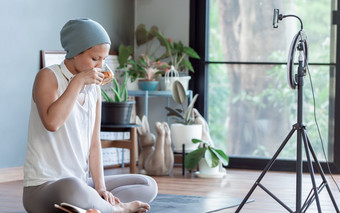 亚洲<strong>癌症</strong>女人喝茶而在线视频流媒体首页健康和技术概念