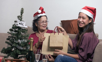 可爱的女儿给她的<strong>老妈妈</strong>。购物袋和礼物为庆祝圣诞节新一年聚会，派对首页
