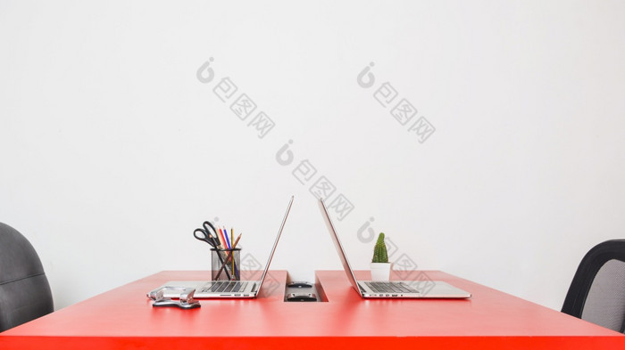 现代工作场所与两个笔记本电脑红色的表格对白色墙决议和高质量美丽的照片现代工作场所与两个笔记本电脑红色的表格对白色墙高质量和决议美丽的照片概念