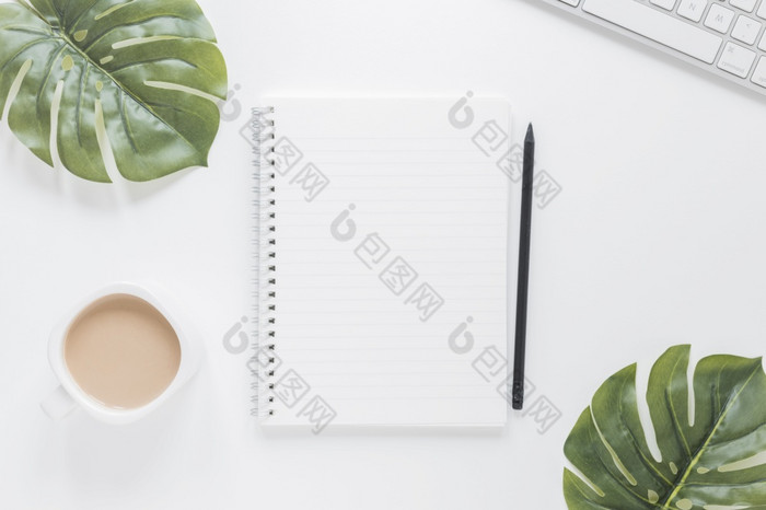笔记本附近咖啡杯键盘表格与绿色叶子决议和高质量美丽的照片笔记本附近咖啡杯键盘表格与绿色叶子高质量和决议美丽的照片概念