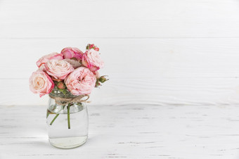 粉红色的玫瑰花玻璃Jar白色木变形背景决议和高质量美丽的照片粉红色的玫瑰花玻璃Jar白色木变形背景高质量和决议美丽的照片概念
