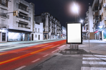 汽车光小径通过附近空白广告牌人行道上城市美丽的照片汽车光小径通过附近空白广告牌人行道上城市