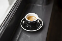 剩下的咖啡黑色的杯窗口窗台上美丽的照片剩下的咖啡黑色的杯窗口窗台上