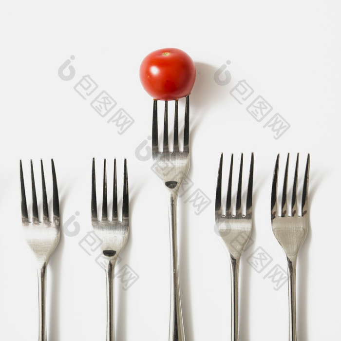 红色的樱桃番茄叉对白色背景美丽的照片红色的樱桃番茄叉对白色背景