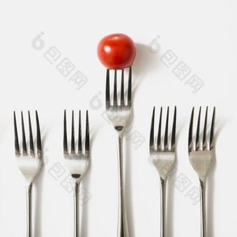 红色的樱桃番茄叉对白色背景美丽的照片红色的樱桃番茄叉对白色背景