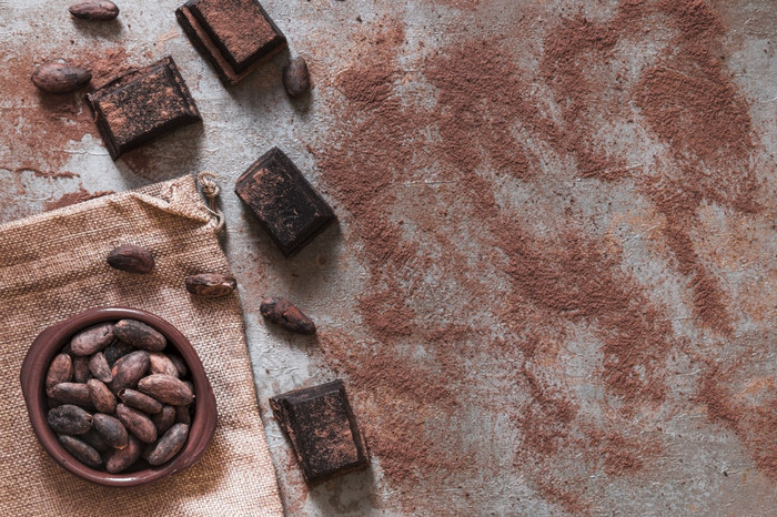 分散可可粉与巧克力块可可豆子碗美丽的照片分散可可粉与巧克力块可可豆子碗