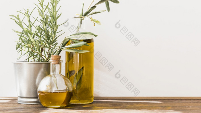 盆栽迷迭香与橄榄石油瓶木表格高决议照片盆栽迷迭香与橄榄石油瓶木表格高质量照片