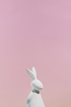 白色兔子小雕像粉红色的背景高决议照片白色兔子小雕像粉红色的背景高质量照片