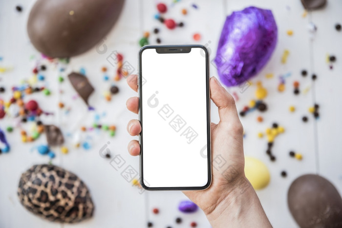 人持有智能手机与空白屏幕复活节鸡蛋高决议照片人持有智能手机与空白屏幕复活节鸡蛋高质量照片