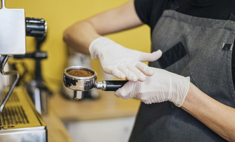一边视图咖啡师与乳胶手套准备咖啡机高决议照片一边视图咖啡师与乳胶手套准备咖啡机高质量照片