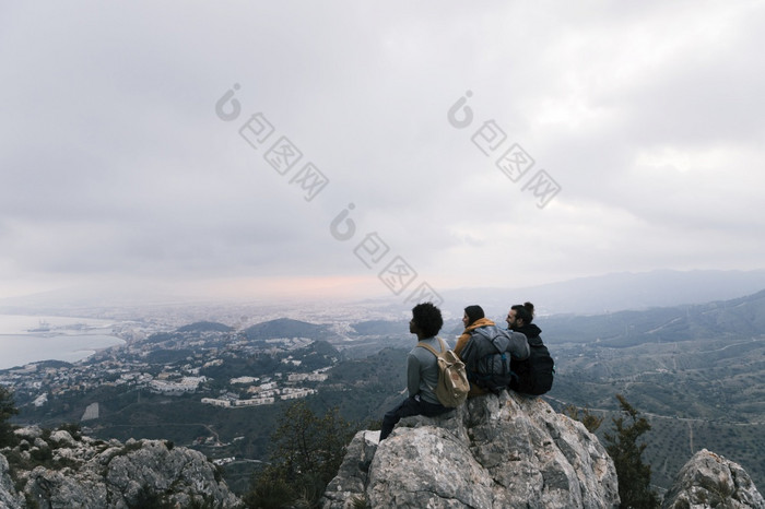 三个朋友坐着前山享受风景优美的视图高决议照片三个朋友坐着前山享受风景优美的视图高质量照片