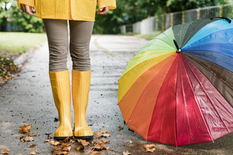 女人雨靴子站色彩斑斓的伞高决议照片女人雨靴子站色彩斑斓的伞高质量照片