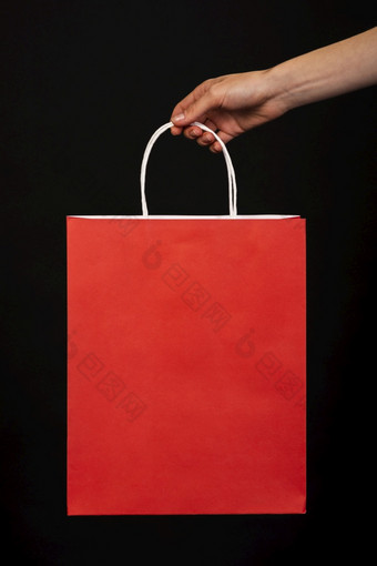 关闭<strong>手持</strong>有<strong>红色</strong>的购物袋黑色的背景高决议照片关闭<strong>手持</strong>有<strong>红色</strong>的购物袋黑色的背景高质量照片
