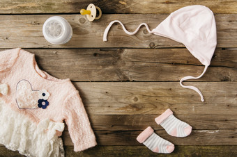 粉红色的婴儿衣服与头饰一对袜子牛奶瓶奶嘴木表格