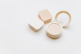 关闭化妆品现实的塑料紧凑的粉与海绵白色背景