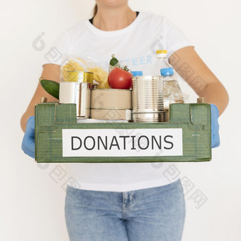 女志愿者与手套持有食物捐赠盒子