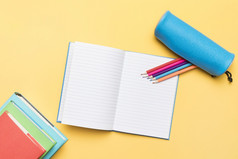 彩色的铅笔组成开放笔记本与空页面