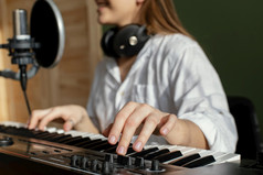 女音乐家玩计划键盘在室内记录首歌