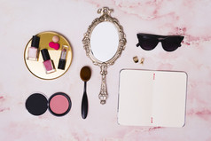 口红指甲波兰的瓶紧凑的脸粉化妆刷手镜子司钻开放空白日记粉红色的背景