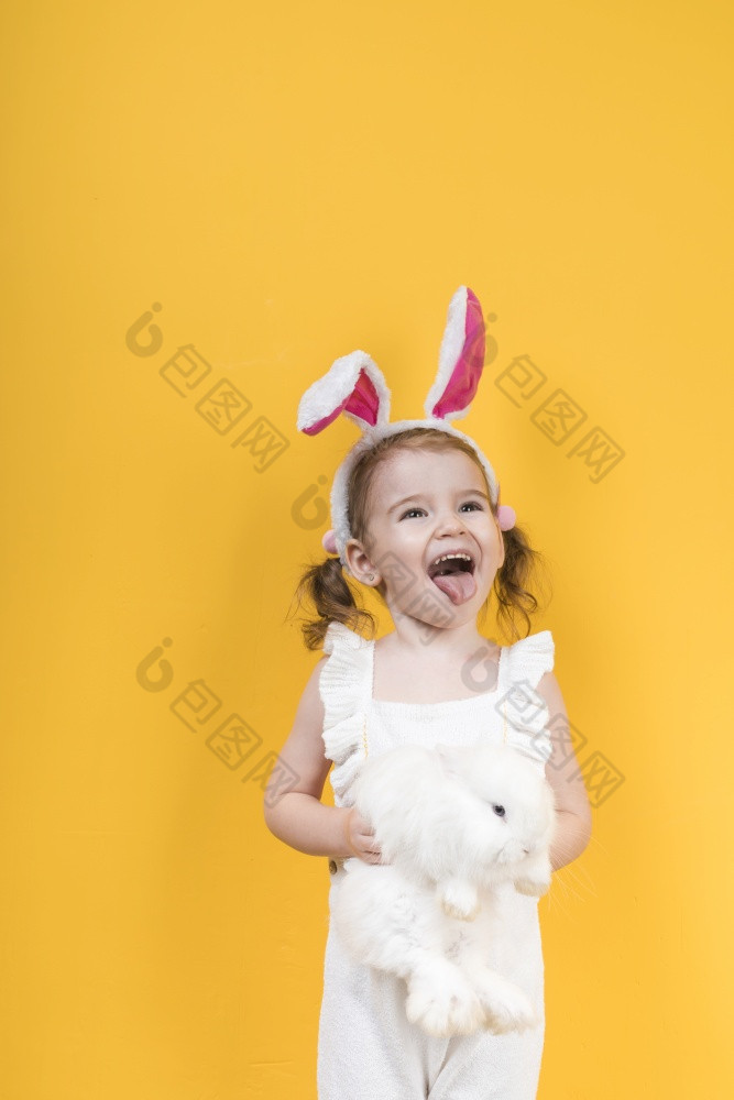 小女孩兔子耳朵与兔子显示舌头