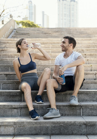 前面视图男人。女人<strong>喝水</strong>在户外而锻炼