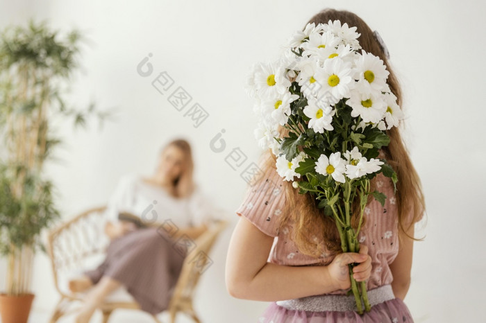 小女孩持有花束春天花惊喜她的妈妈。