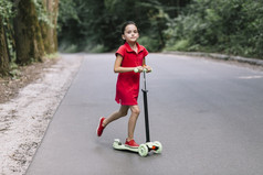 小女孩骑推踏板车路