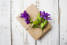 前视图紫色的花系与礼物盒子白色木背景