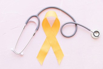 肉瘤骨癌症黄色的丝带与<strong>听诊器</strong>粉红色的背景