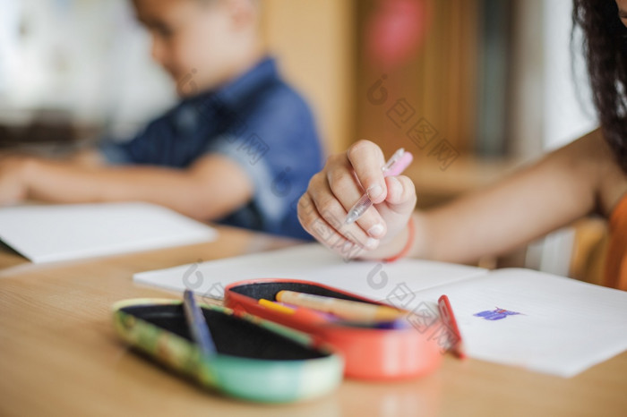 小学生坐着桌子上与笔记本电脑