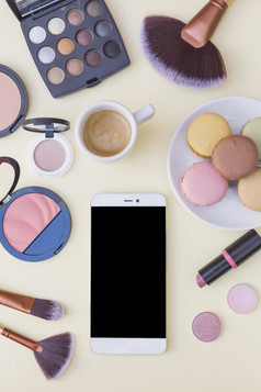 手机屏幕咖啡与蛋白杏仁饼化妆品产品米色背景