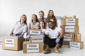 笑脸<strong>志愿</strong>者摆姿势在一起与捐赠盒子与食物