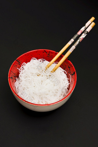 大米粉丝碗与筷子黑色的表面