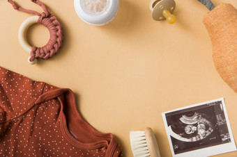 婴儿服装刷玩具奶嘴塞梨超声图片橙色背景