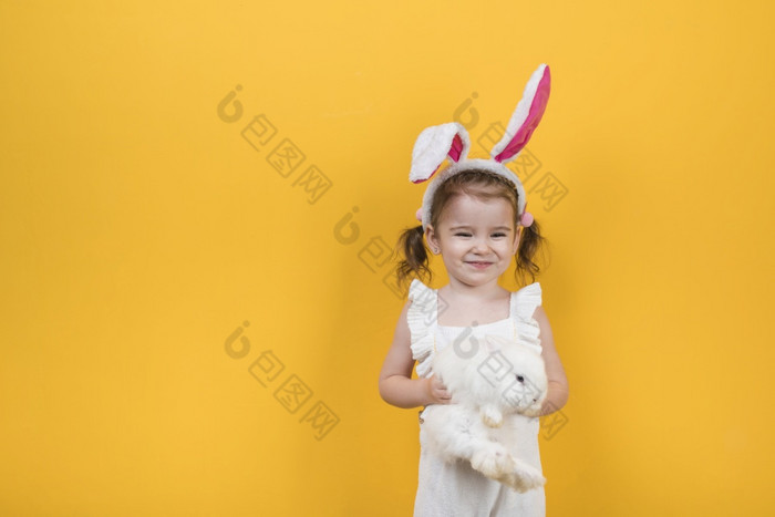 可爱的女孩兔子耳朵站与兔子