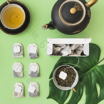 行不同的茶袋与茶杯茶壶苍<strong>白</strong>的<strong>绿色背景</strong>