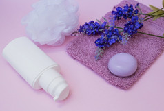 肥皂毛巾薰衣草花丝瓜化妆品瓶粉红色的背景