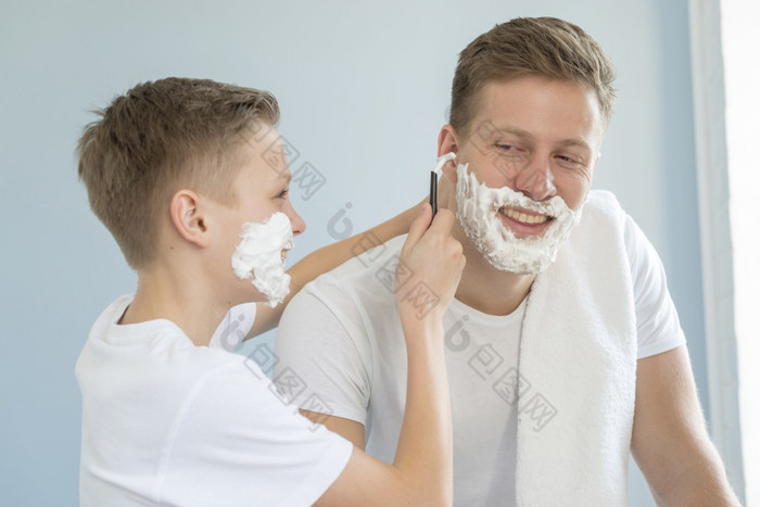 儿子帮助他的父亲刮胡子