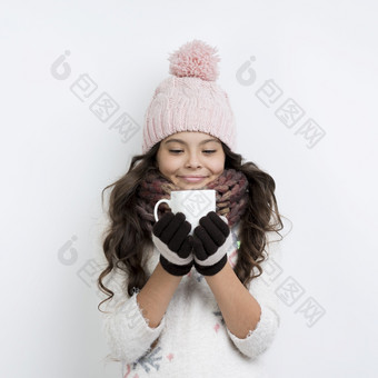 年轻的女孩穿冬天衣服喝茶