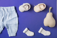 粉红色的婴儿鞋子袜子婴儿裤子与塞梨明亮的蓝色的背景