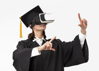 女人与毕业袍帽穿虚拟现实耳机女人与毕业袍帽穿虚拟现实耳机