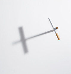 高角视图交叉标志使从香烟与影子孤立的白色背景