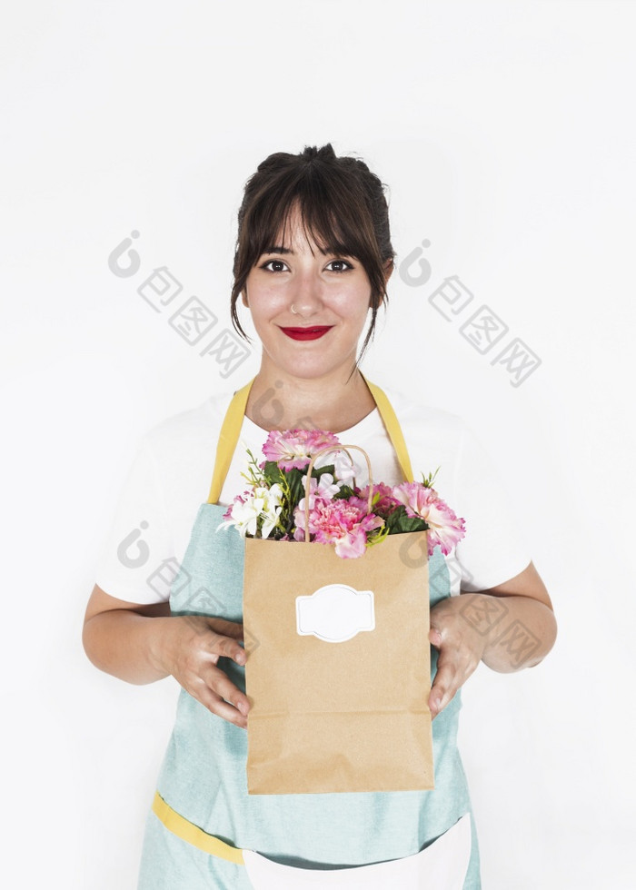 微笑女花店持有纸袋完整的新鲜的花