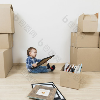 小<strong>婴儿</strong>男孩坐着移动纸板盒子看<strong>图片</strong>框架新首页