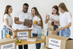 很多志愿者准备盒子与食物捐款使用平板电脑