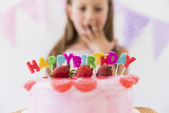 惊喜可爱的女孩美味的草莓生日蛋糕