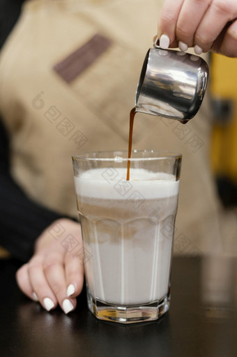 前面视图女咖啡师倒咖啡牛奶玻璃