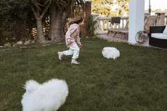 女孩可爱的白色小狗玩在户外
