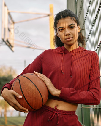 女人持有<strong>篮球</strong>在户外